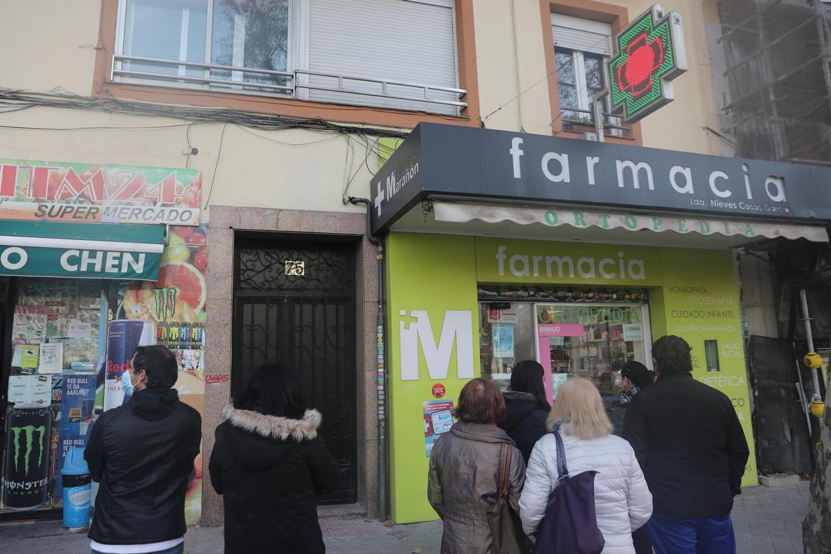 Varias personas hacen cola en una farmacia para adquirir un test de antígenos.