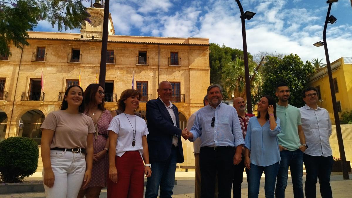 Vicent Grimalt y Rafa Carrió chocan la mano, rodeados de los concejales del nuevo gobierno de PSPV y Compromís