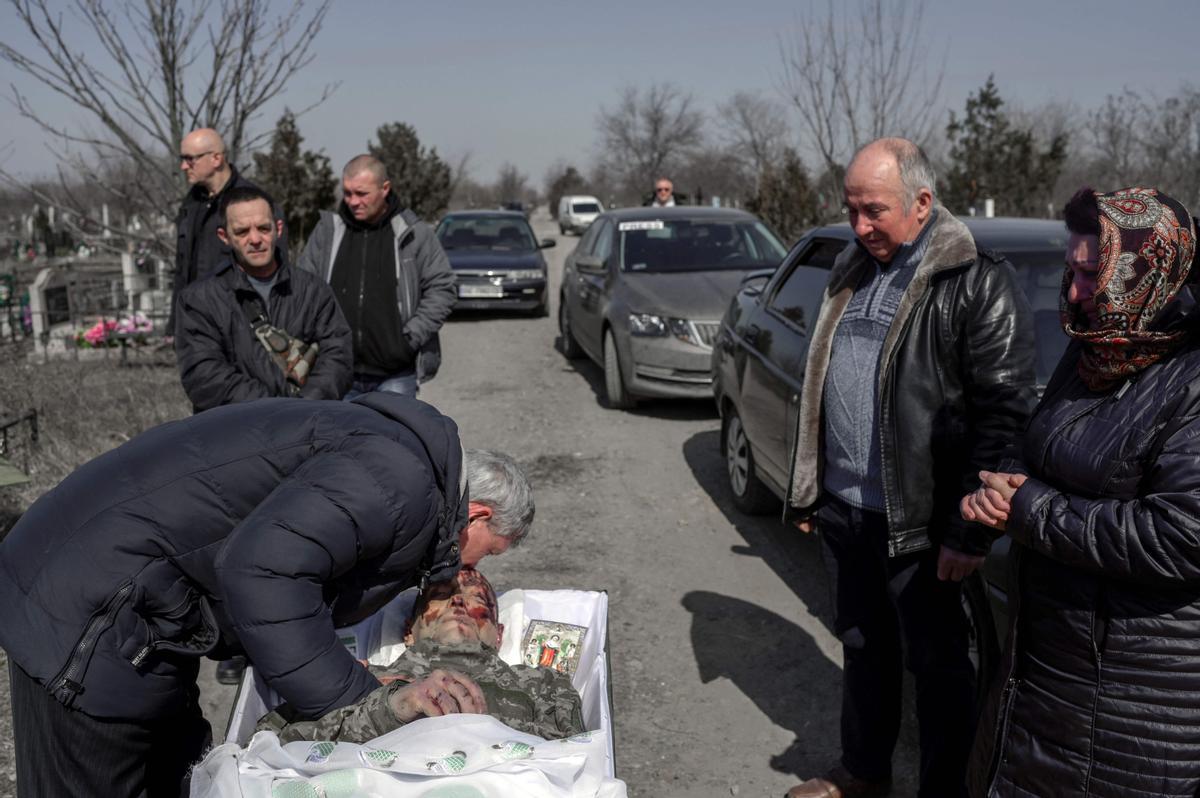 La gente llora a un soldado asesinado por un cohete ruso en la escuela militar, en el cementerio de Mykolaiv, en el sur de Ucrania.