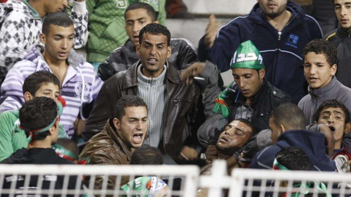 Aficionados del Al Wihdat trasladan a un hombre herido en los disturbios ocurridos tras el partido con el Al Faisali, anoche, en Ammán.