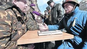 Un home parla amb un oficial ucraïnès en un centre de reclutament a l’aire lliure a Kíev, ahir.