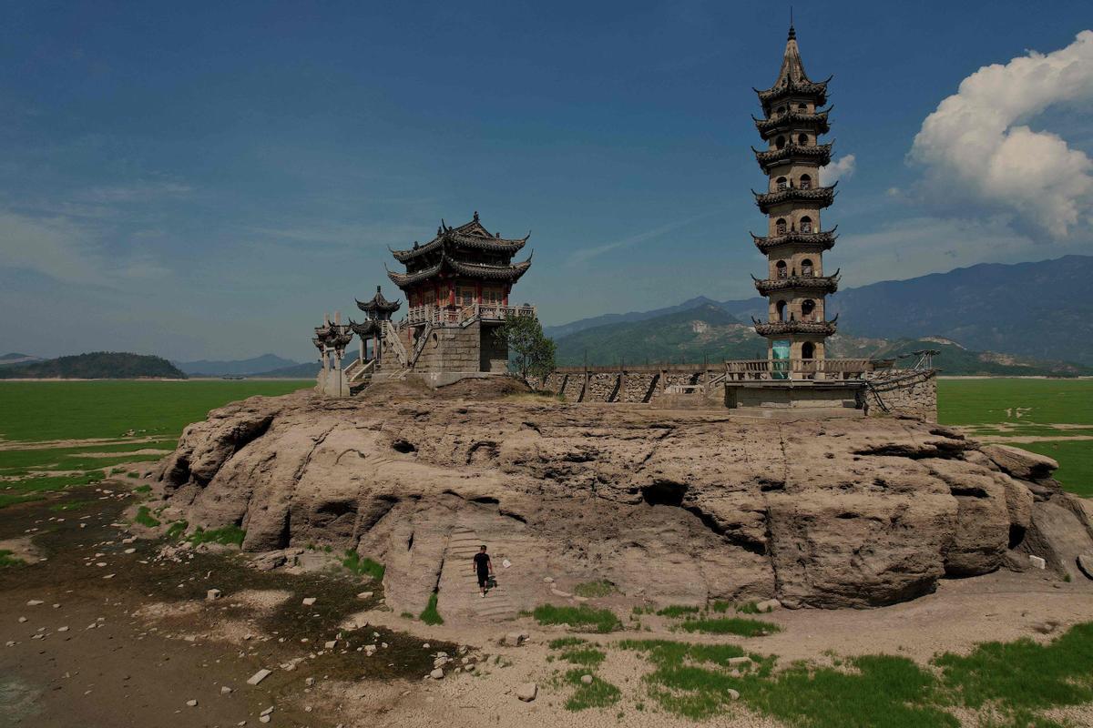Luoxing Dun, una pequeña isla con antiguos templos en la cima, en el lago Poyang, el lago de agua fresca más grande de Juijiang, en China central. En la imagen se aprecia que está al descubierto una parte de tierra que, normalmente, solía estar sumergida bajo el agua. Imagen del 23 de agosto del 2022.