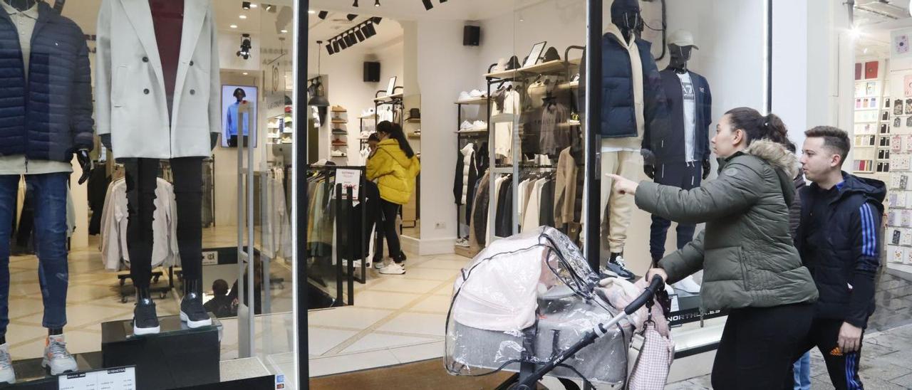 Una pareja accede a una tienda de moda localizada en la céntrica calle Gondomar.