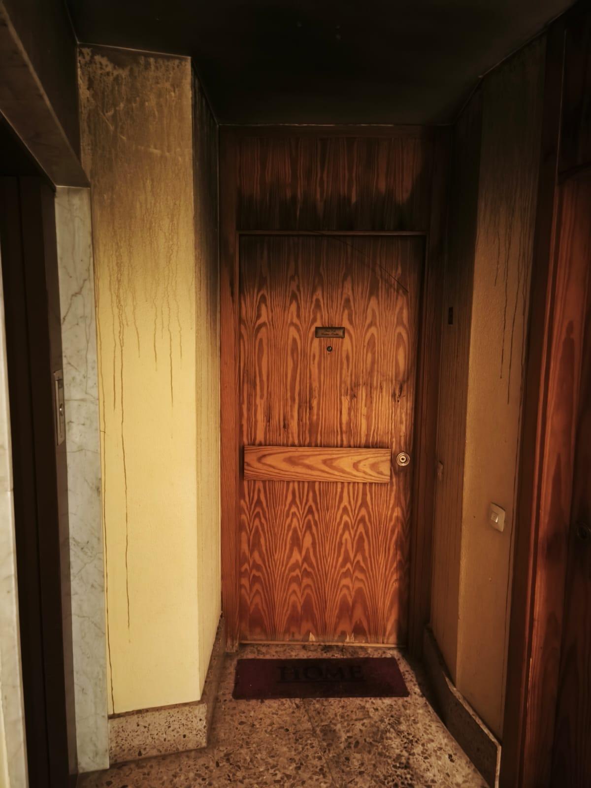 Puerta de la vivienda del segundo piso donde se ha declarado el fuego.