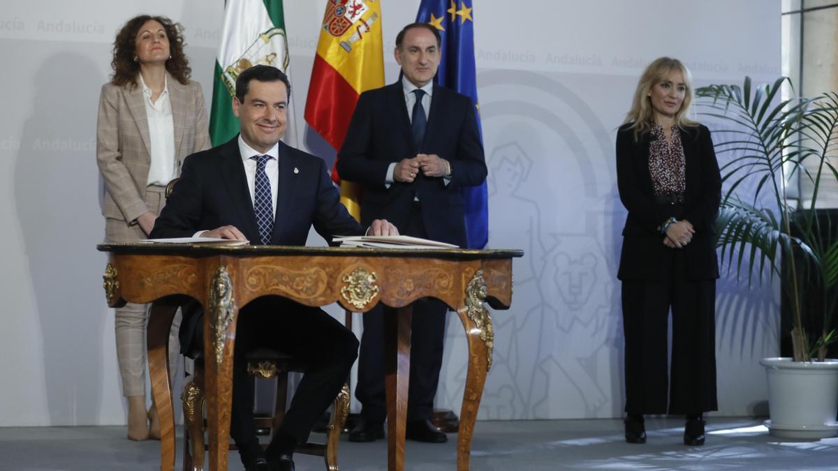 El presidente de la Junta, Juanma Moreno, firma el paquete de ayudas en presencia de los representantes de patronal y sindicatos.