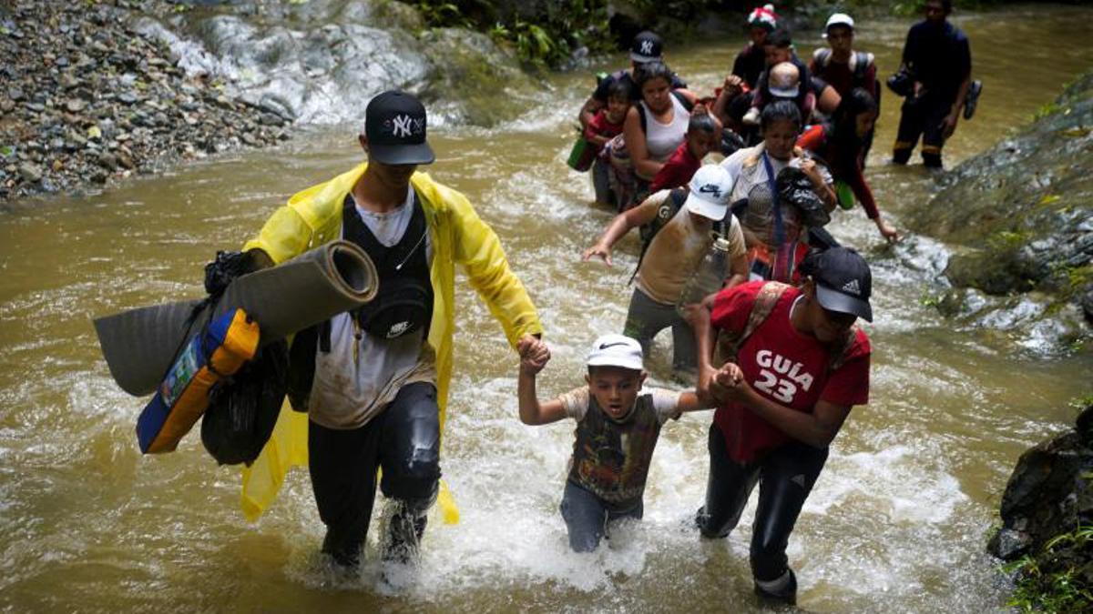 Migrantes cruzan el río Muerto en el Tapón del Darién, de viaje hacia los Estados Unidos, en Acandi, Colombia