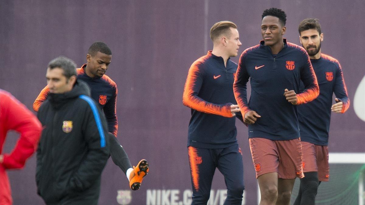 Yerri Mina, por delante, de Ter Stegen y Andre Gomes, en un entrenamiento en la Ciutat Esportiva