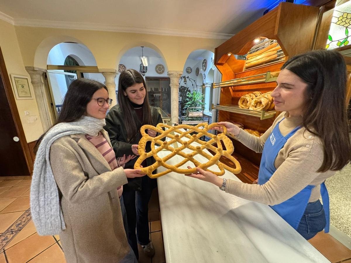 Belén Carrasco vende una rosca de la Candelaria a dos jóvenes de Montilla.