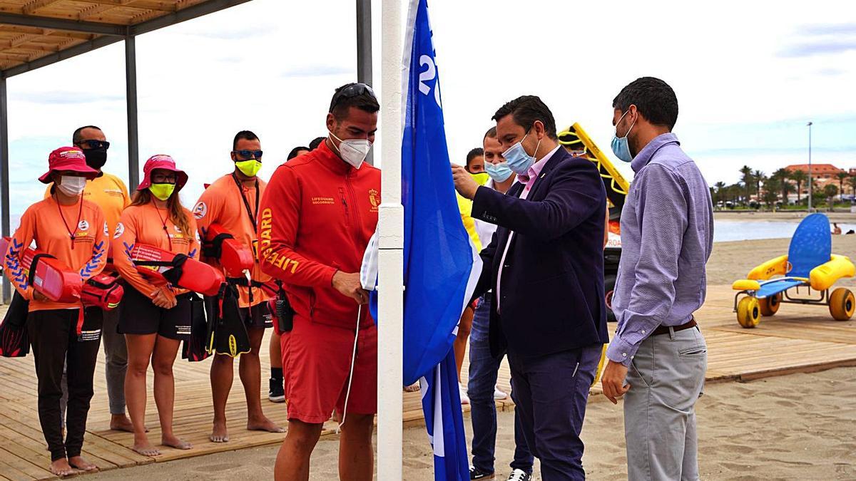 El alcalde de Arona, José Julián Mena, iza la bandera azul en la playa de Las Vistas junto a socorristas.