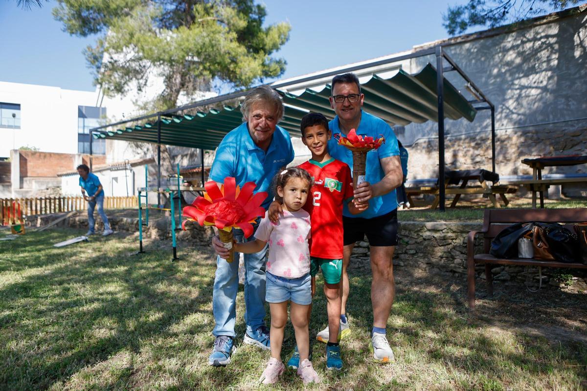Nens agafant la torxa olímpica acompanyats dels voluntaris de CaixaBank