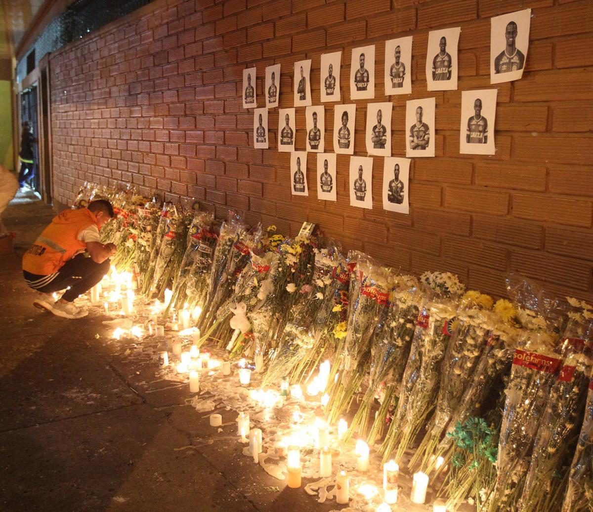 MED19. MEDELLÍN (COLOMBIA), 30/11/2016.- Un hombre enciende unas velas frente a fotos de los jugadores del equipo de fútbol Chapecoense durante un homenaje al equipo hoy, miércoles 30 de noviembre de 2016, en Medellín (Colombia) a las afueras del estadio Atanasio Girardot. Miles de personas abarrotaron esta noche el estadio Atanasio Girardot de Medellín para rendir un homenaje póstumo al equipo de fútbol brasileño Chapecoense, la mayoría de cuya plantilla pereció en el accidente aéreo del pasado lunes cuando se dirigían a esta ciudad del noroeste de Colombia EFE/LUIS EDUARDO NORIEGA A.