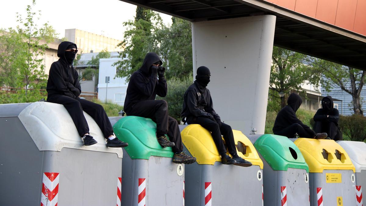 Estudiantes subidos encima de unos contenedores que sirven de barricadas, en la UAB.