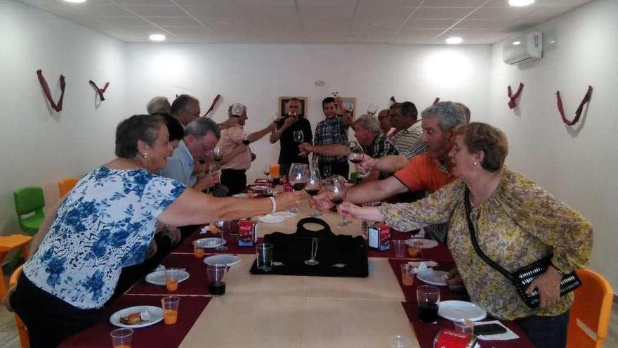 Vecinos de Sanzoles brindan tras la cata maridaje de vino y productos de la tierra.