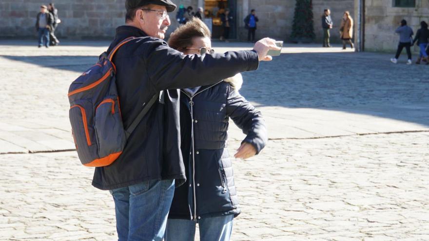 Turistas sacándose un ‘selfie’ en la plaza del Obradoiro. jesús prieto