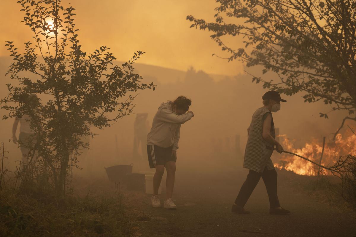 Vecinos trabajan en labores de extinción del incendio forestal de Carballeda de Avia (Ourense) este domingo. La ola de incendios que afecta al noroeste de España no da tregua este domingo. Tras una semana de incendios que han causado tres muertos, miles de hectáreas quemadas y miles de desalojados por las llamas, el país se encuentra devastao. En la región de Galicia ardieron ya 50.000 hectáreas y en la de Castilla y León 3.500 personas permanecían fuera de sus hogares. EFE/ Brais Lorenzo