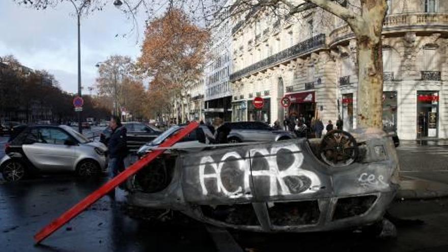 Un cotxe cremat i bolcat al mig del carrer a París