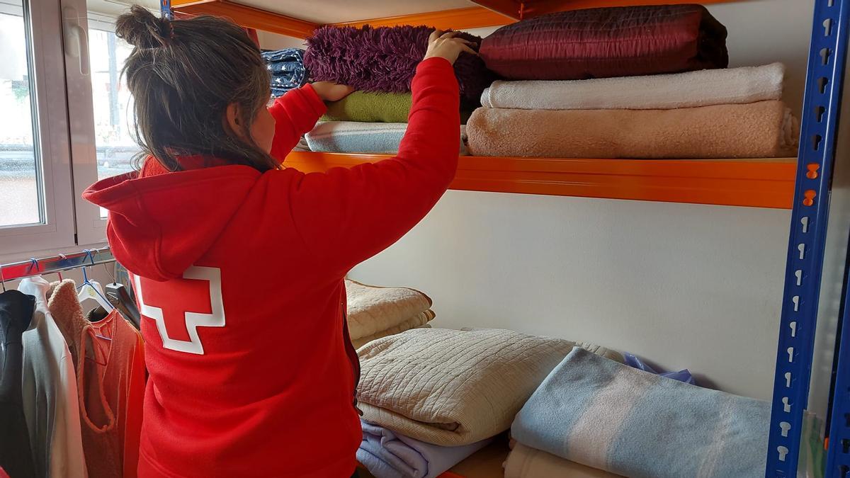 Una tècnica de Creu Roja al Bages desant mantes al rober de l'entitat