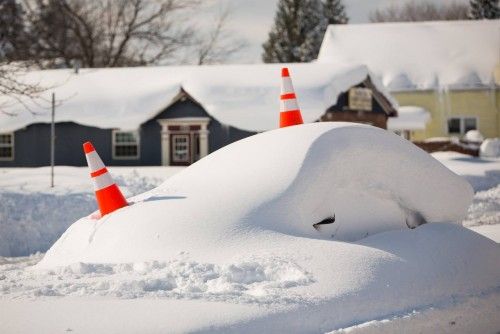 Abandon car marked by orange cones is pictured buried under snow in Buffalo, New York