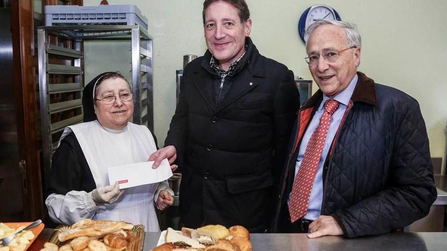 Sor Dolores Da Silva recibe la donación de manos de Eduardo Quesada; a la derecha, Juan P. Zaldívar.