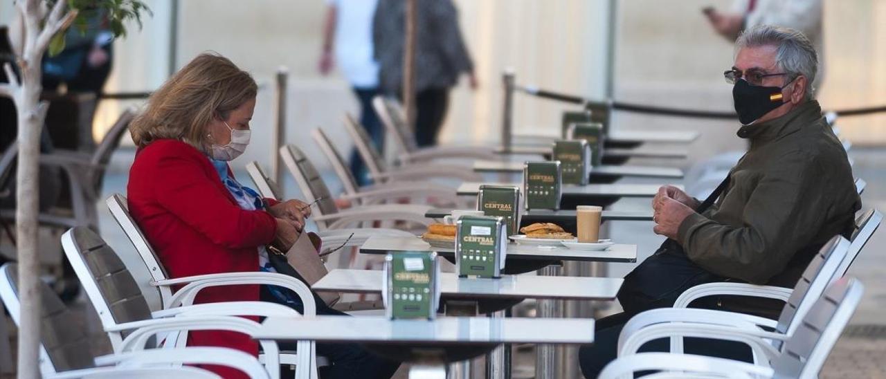 Dos personas en la terraza de un bar.