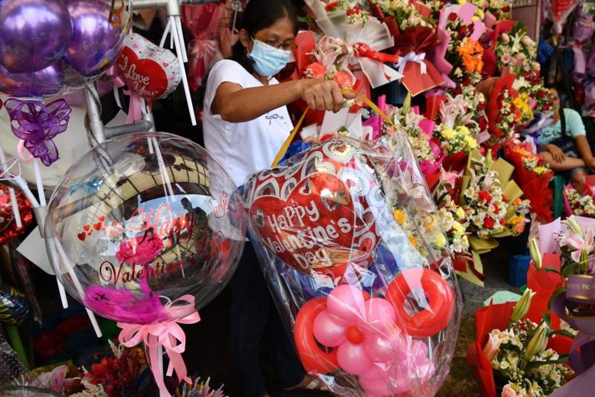 La gente compra ramos de flores el Día de San Valentín en un mercado de flores en Manila