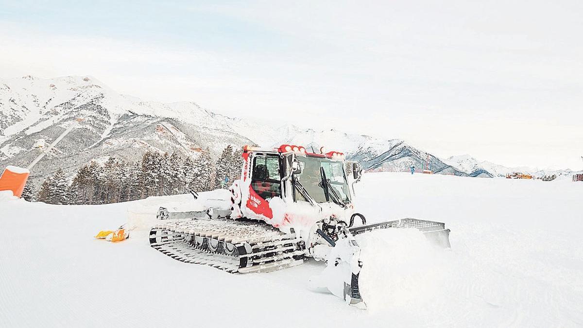 Una máquina pisanieves trabaja para acondicionar las pistas de esquí en el área esquiable de Vallnord