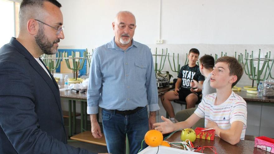 Un joven estudiante del Colegio Santa María explica al alcalde Benlloch las líneas del proyecto en el que trabaja.