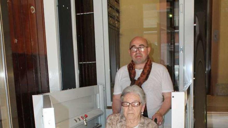 Amada Díaz junto a Santiago López, ayer, en el elevador de su portal de la calle Valentín Masip.