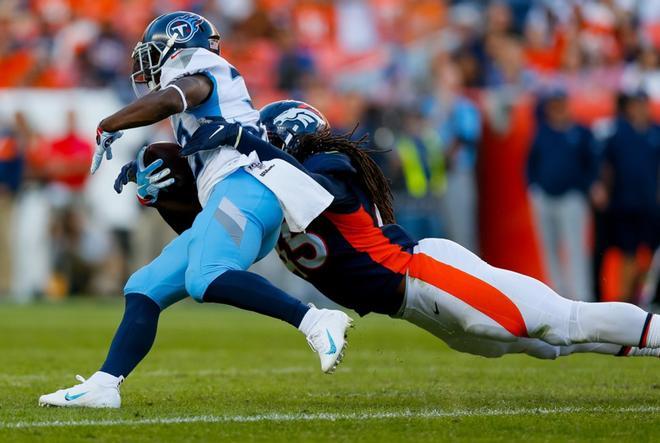 El apoyador A.J. Johnson # 45 de los Denver Broncos aborda al corredor Dion Lewis # 33 de los Tennessee Titans durante el último cuarto en Empower Field en Mile High.