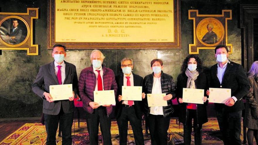 Sobre estas líneas Pascual Sanabria, tercero por la izquierda, recibe el premio del Colegio de Médicos de Madrid. A la derecha, en el quirófano junto a una madre y una sanitaria observan a un pequeño. | |  FOTOS ICOMEM Y JOSÉ LUIS ROCA