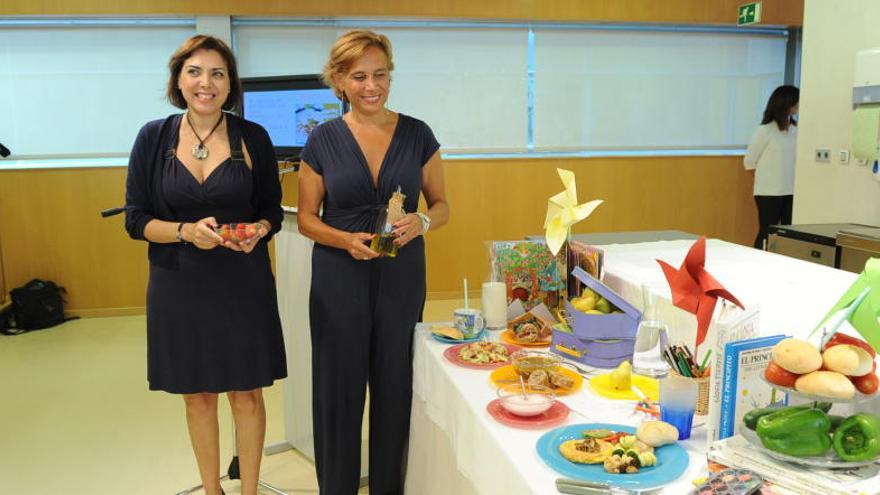 El menú infantil elaborado por expertos en nutrición del Centro de Cualificación Turística de la Región, que  fue alabado por Marta Garaulet (d) y la consejera.