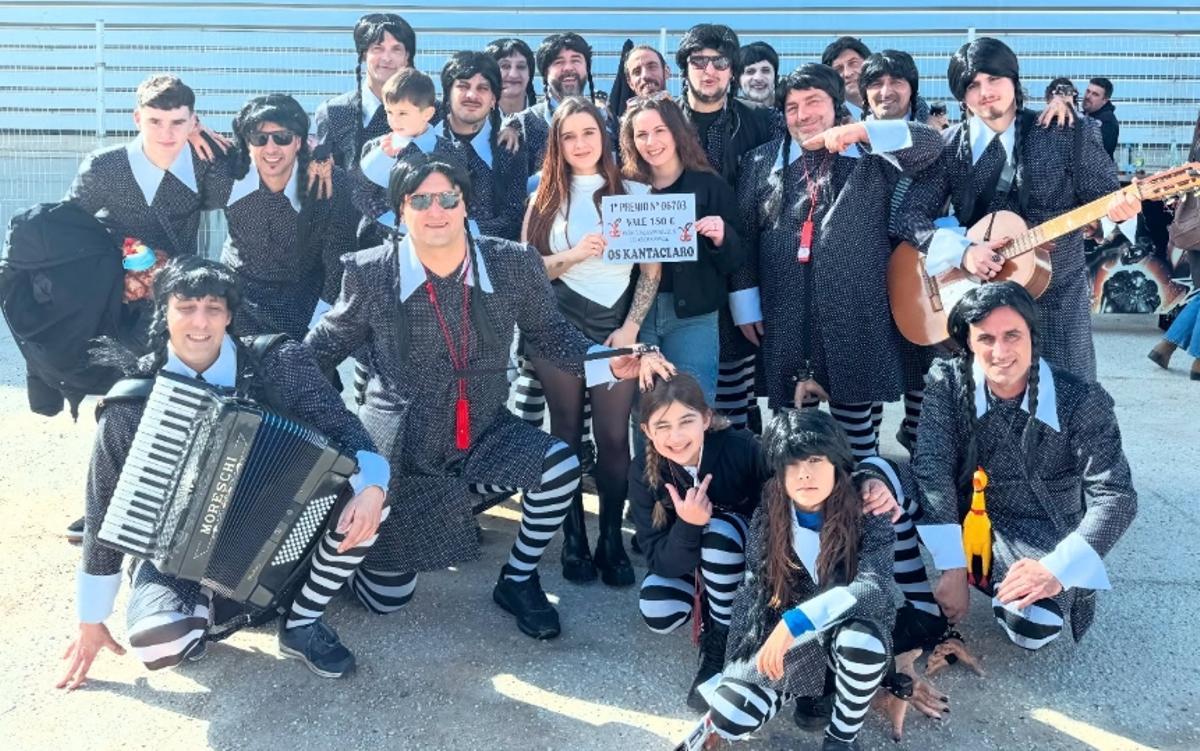 Los integrantes de Os Kantaclaro, que este año se disfrazan de Miércoles Addams (personaje de La familia Addams), que aprovecharon el Entroido para entregar el premio de su sorteo navideño, cuya ganadora fue la joven Andrea.