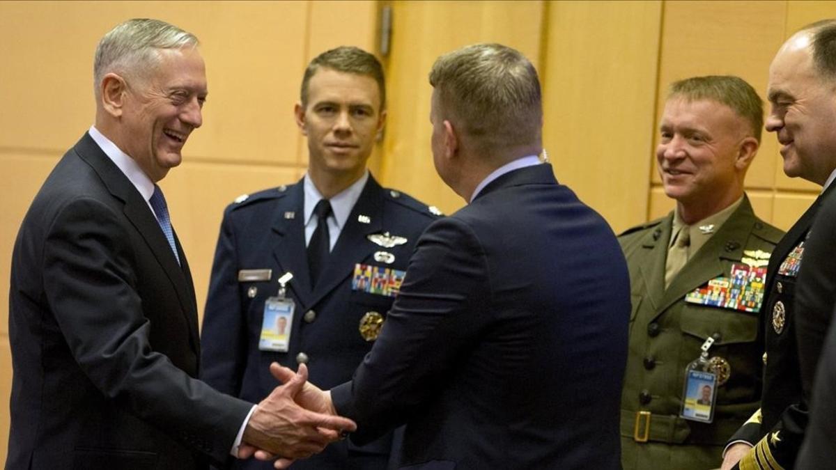 Jim Mattis conversa con miembros de su delegación antes del comienzo de la cumbre.