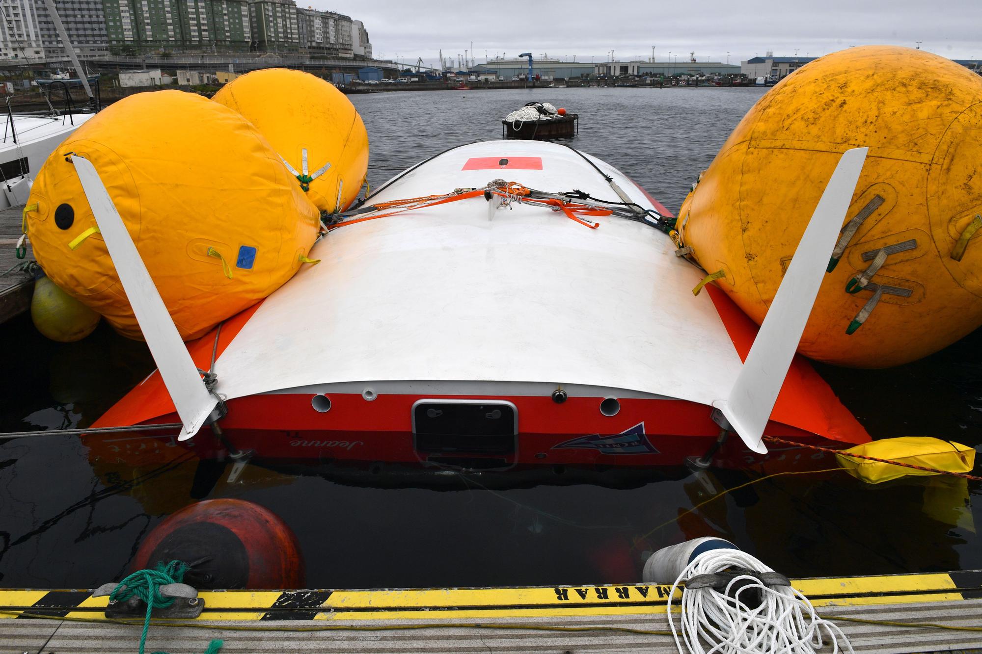 El velero "Jeanne Solo Sailor", propiedad del navegante francés Laurent Camprubi, volcado y amarrado en el pantalán del puerto marítimo de Oza