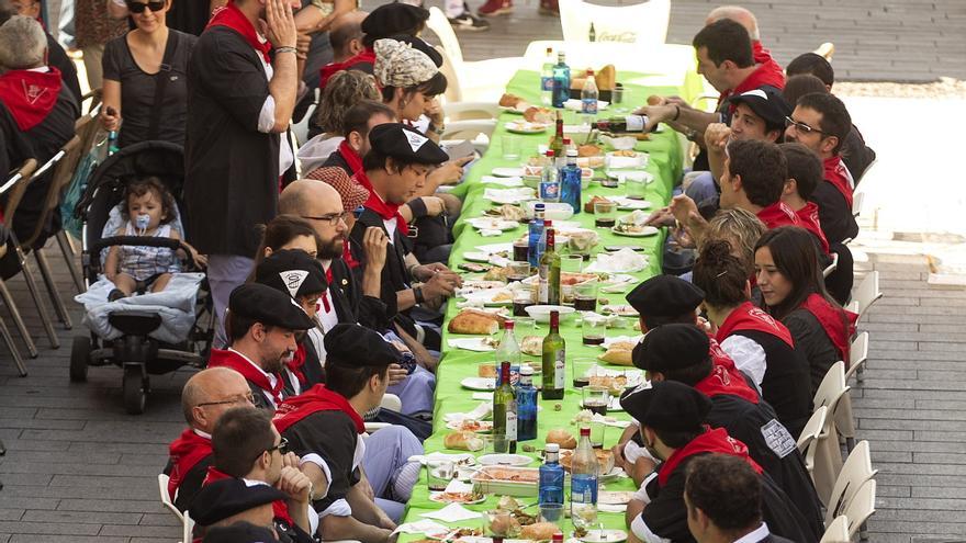 Un numeroso grupo de personas come al aire libre.
