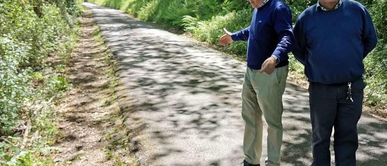 Fernando Rosales y Juan Luis García supervisan el ancho de la carretera de Valle, en Piloña, ayer.