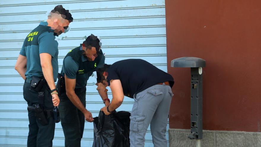 Guardia Civil y Policía Judicial buscan pistas en una papelera situada junto al lugar del suceso.