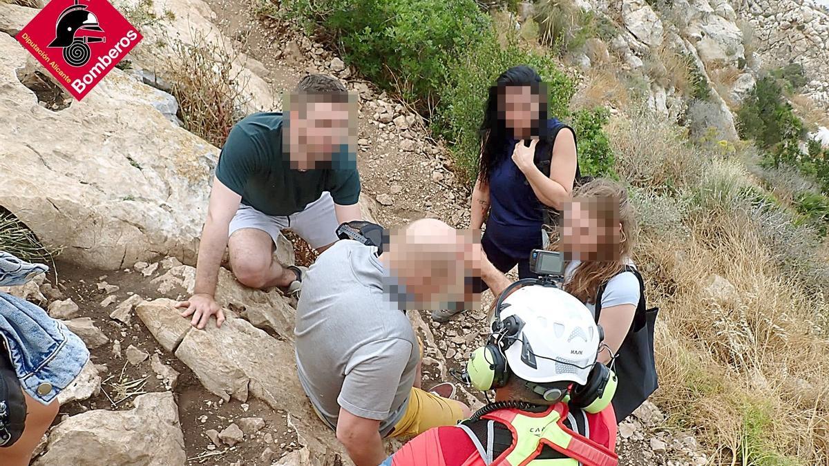 El senderista accidentado junto al médico del grupo de rescate y otros excursionistas