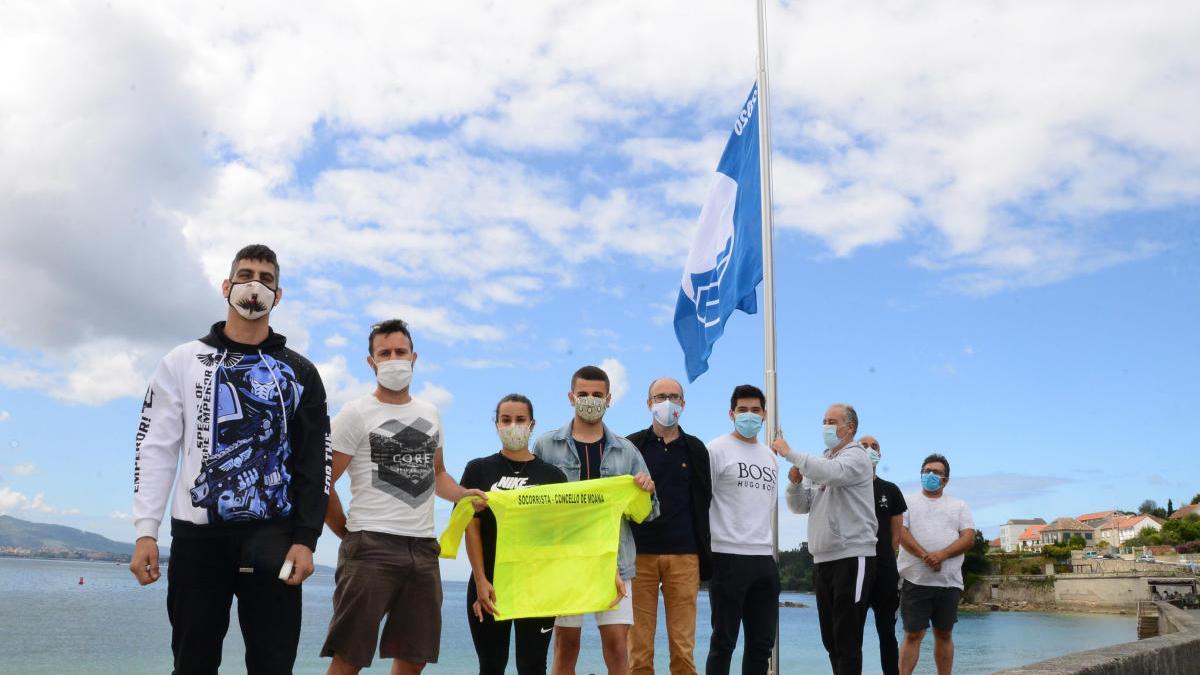 El edil de Medio Ambiente (centro, con los socrristas y patrones, iza la bandera azul en O Con.// Gonzalo Núñez