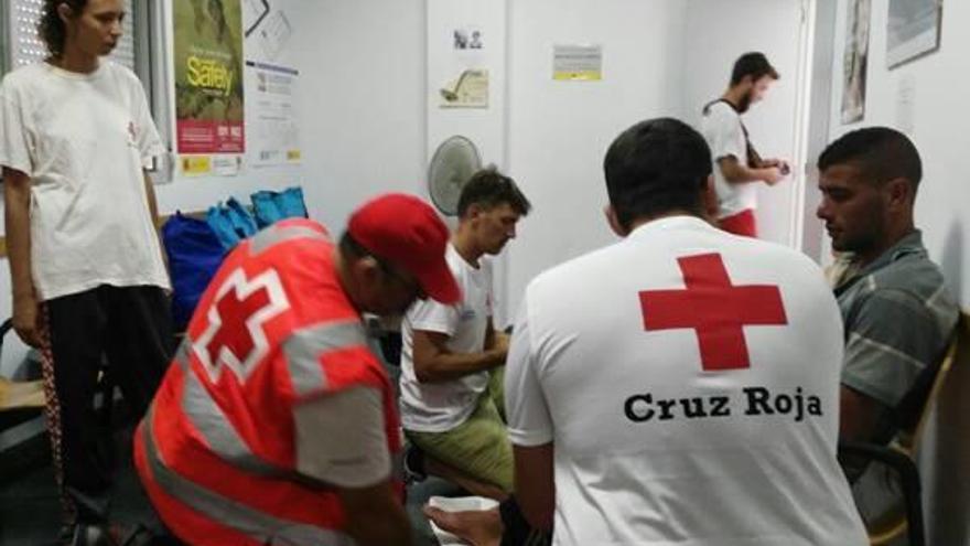 Personal de Cruz Roja atendiendo ayer a algunos de los inmigrantes.