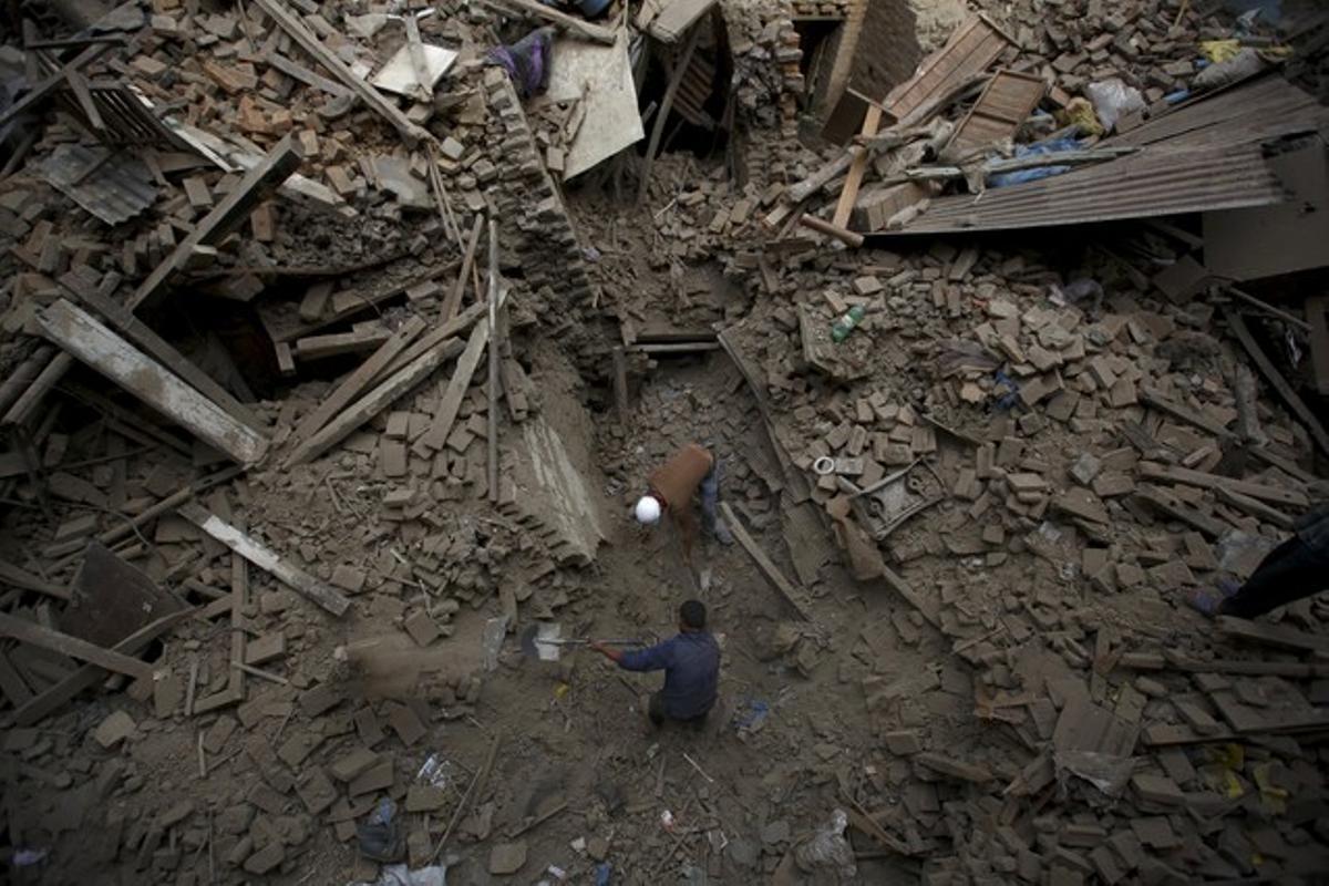 Els voluntaris busquen una família atrapada a la runa d’un edifici derruït pel terratrèmol.