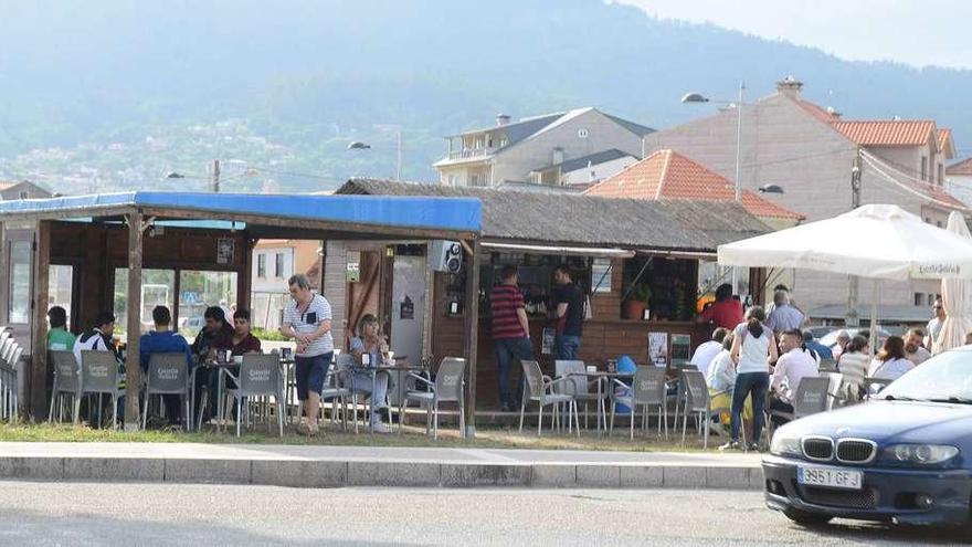 Clientes, ayer, en el chiringuito abierto en mayo en el acceso a la antigua isla de Samertolaméu. // Gonzalo Núñez