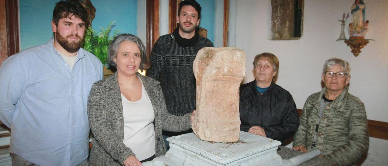 Vecinas de San Fiz e integrantes de la asociación de Amigos do Patrimonio de Toén, con el ara romana que se usa en la capilla como pila de agua bendita.