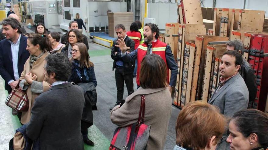 Iglesias, en el centro con chaleco rojo, guía a los visitantes por las instalaciones de Cartonajes Vir en Meres.