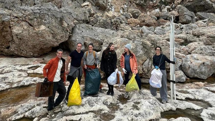 Una parrilla, sombrillas, un horno, una tortuga muerta y mucha basura: siete voluntarios se unen para limpiar una cala escondida del norte de Ibiza