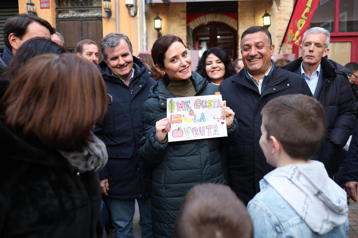 Isabel Díaz Ayuso, en Ávila, con un cartel en el que se lee: "Me gusta la fruta", en una imagen distribuida por el PP de Madrid.