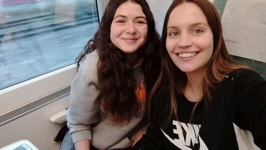 Nerea Pérez, a la izquierda, junto a su coordinadora, Alejandra Hevia, ayer, viajando a Madrid.