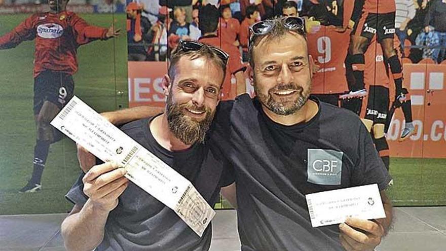 Dos aficionados muestran felices sus entradas para el partido ante el Granada.