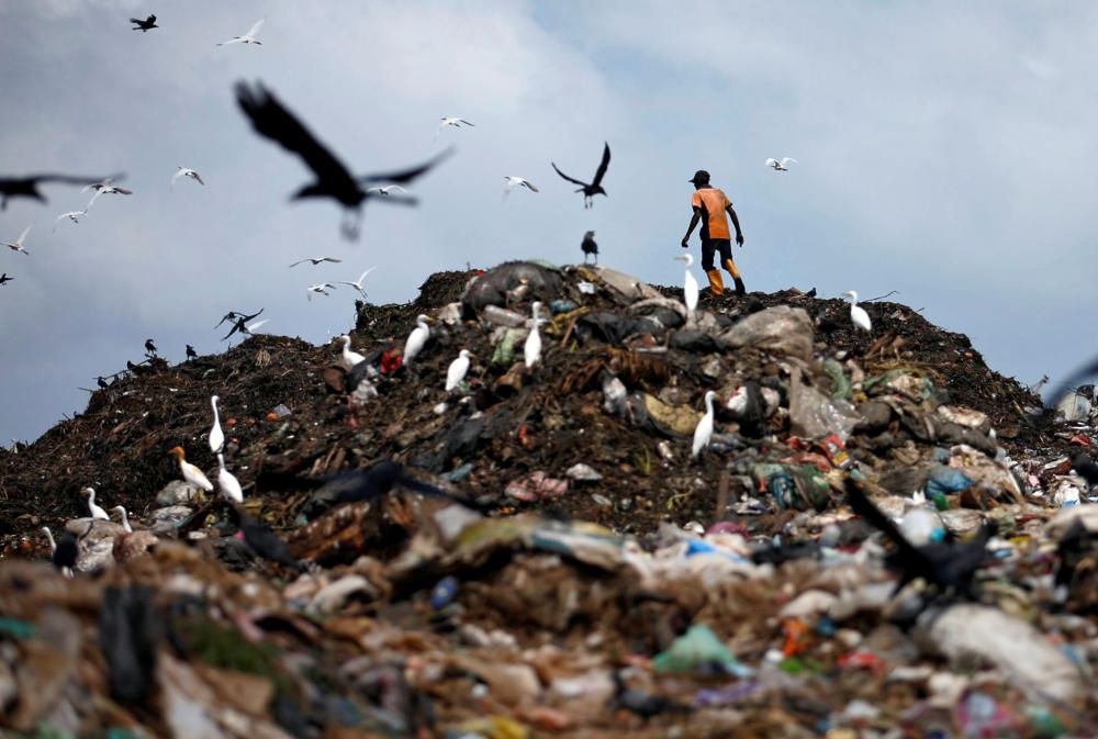 A man collects plastic for recycling in a ...