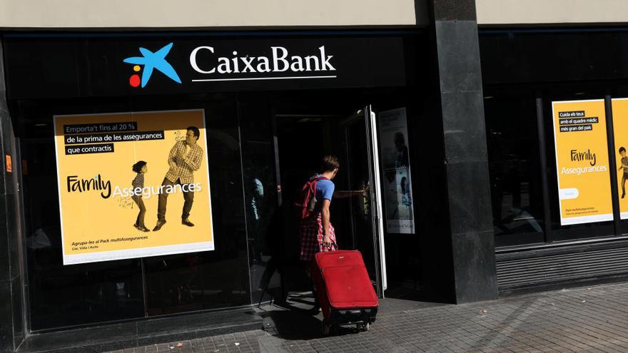 Un cliente accede en Barcelona a una oficina de CaixaBank.